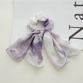 Detailansicht des lila Tie-Dye Chiffon-Haargummis mit eleganten langen Bändern auf Weiß - Tie-Dye Lila