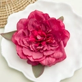 Dettaglio dell'elegante molletta per capelli a forma di peonia magenta con foglie verdi - Peonia Rossa