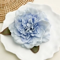Dettaglio del fermaglio per capelli a piva azzurra in seta con foglie verdi su piatto - Peonia Blu