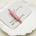 Detalle de la pinza para el pelo rosa con letras doradas France handmade en un plato - Rosa Crema