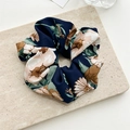 Primer plano de scrunchie floral de satén vintage sobre fondo de mármol - Azul Marino