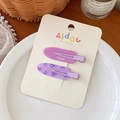 Primer plano de dos pinzas para el cabello moradas con texto grape y diseño de flores - Uva carnosa