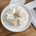 Primer plano de coletero de encaje crema con bordado detallado en plato de cerámica - Blanco