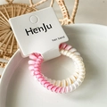 Detailed macro view of pink and white spiral telephone wire hair band on a white ceramic bowl - Gradient Rose Pink