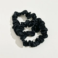 Close-up of black elastic hair scrunchies with subtle metallic shimmer and fabric texture - Black