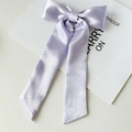 Detalle de lazo para el cabello en satén lavanda con textura suave y brillo de seda - Violeta Claro