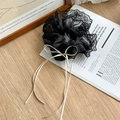 Detailed close-up of a black lace scrunchie featuring a delicate white ribbon bow design - Black