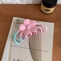 Pink and blue gradient flower hair claw clip displayed on an artistic magazine cover - Flower Style
