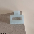 Detail of a minimalist light blue rectangular matte hair claw clip in a soft aesthetic setting - Small Square / Blue