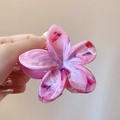 Detail der pink-weißen Marmortextur auf Blumenhaarklammer mit Acetat-Oberfläche - Holografisches Rosa