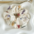 Dettaglio dell'elastico in tessuto floreale con stampa lavanda ed etichetta - Beige