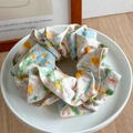 Close-up of floral fabric scrunchie on a white ceramic plate with soft natural lighting - Fairytale Pattern Edge