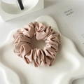 Detailed view of the dusty rose satin fabric folds on a premium elastic hair scrunchie - Pink