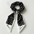 Detalle de coletero con lazo de lunares en tejido satinado y cintas decorativas - Fondo Negro Lunares Blancos Cinta / Negro