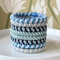 Close-up of blue and white woven elastic hair ties set in a minimalist white ceramic tray - Blue Series
