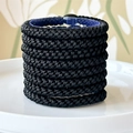 Detail of high-elasticity black braided hair ties on a blue holder in a set of eight - Black