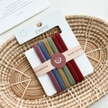 Close-up of high-elasticity colorful hair ties in a rustic basket with ins-style card - Wide Dark Multicolor