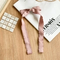 Detailansicht der rosa Haarspange mit Faltenstoff-Schleife und langen Bändern auf Magazin - Koreanisches Rosa