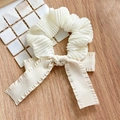 Detail of cream white pleated scrunchie with a long bow ribbon on a wooden background - Pleated Bow Scrunchie Cream