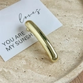 Macro detail of the polished golden curved hair clip on a minimalist stone tray display - Plain Gold