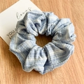 Detailed texture of blue striped fabric scrunchie with white wavy embroidery patterns - Blue Striped