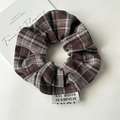 Dettaglio dell'elastico per capelli vintage a quadri marroni con etichetta in tessuto - Marrone