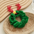Close-up of green velvet Christmas hair scrunchie with red antlers and festive bells - Green Antlers