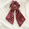 Detail eines Halloween Samt-Scrunchies mit Sternen und langen Bändern in Lila und Orange - Stern-Streamer