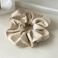 Détail rapproché d'un chouchou en cuir PU crème avec texture plissée douce et couture fine - Blanc Cassé