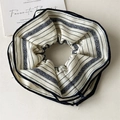 Gros plan d'un chouchou en tissu beige avec rayures bleues et motifs ethniques - Rayé Rétro Beige