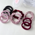 Detalle de gomas de pelo de cable y coleteros en tonos rosa y burdeos elegantes - Rosa