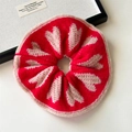 Macro shot of red knitted scrunchie featuring cream heart patterns and soft wool texture - Red Heart Knitted Scrunchie
