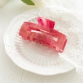 Detail of large marble red and white acrylic hair claw clip on a decorative plate - Hollow Light Red