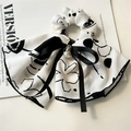 Dettaglio di scrunchie floreale a inchiostro con fiocco nero e ciondolo con perla - Bianco Inchiostro