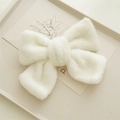 Détail de la texture douce et du tissu pelucheux blanc du nœud papillon pour les cheveux - Blanc