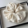 Close-up of soft plush milk white velvet scrunchie on a display tray for winter hairstyles - Large Plush Off-White