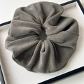 Close-up of a large dark grey plush scrunchie with soft fleece texture in a display tray - Large Plush Gray