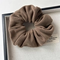Macro shot of coffee brown plush scrunchie showing soft faux fur texture on a linen tray - Small Plush Brown
