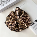 Detalle de un coletero grande con estampado de leopardo sobre una revista de moda - Leopardo Café Claro