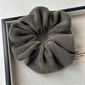 Close-up of dark brown plush velvet hair scrunchie with soft fleece texture in a display tray - Small Plush Gray