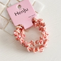 Detail of pink and white spiral braided hair band on card with seashell tile background - Pink