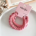 Detalle de gomas elásticas para el pelo en rosa con textura tejida en plato decorativo - Rosa