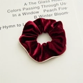 Detailed texture of burgundy velvet scrunchie with elastic rubber core and beige piping edge - Burgundy