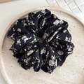 Detalle del coletero negro con estampado floral blanco sobre un plato de piedra - Estilo Floral Grande (FQ4212) / Negro Floral