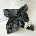 Detail view of floral scrunchie with lace bow and hanging pearl pendant on white surface - Floral Black Square Bow