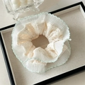 Dettaglio dell'elastico in pizzo crema con ricamo verde menta e texture plissettata - Verde