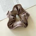 Macro shot of elegant champagne satin scrunchie with silky texture and ruffled edges - Taro Purple Wood Ear Edge