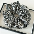 Dettaglio di scrunchie a righe bianche e nere con etichetta floreale su un vassoio - Stile a Righe Nero Beige / A Righe Crema E Nero