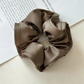 Close-up of brown satin scrunchie showing glossy texture and elegant pleated details - Brown Wood Ear Edge
