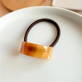 Makro-Detail von bernsteinfarbenem Acetat-Haargummi mit goldener Frankreich-Handarbeit-Gravur - Braun